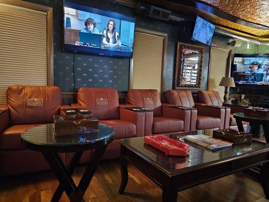 Comfy leather loungers with built in drink holders, ample ashtray supply, and screens everywhere.
