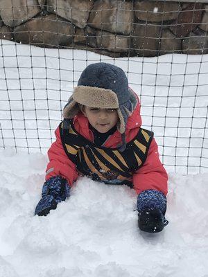 Little Rey playing in the snow with his friends and teachers
