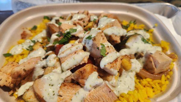 Chicken rice howl with yellow squash onions cilantro and a garlic sauce