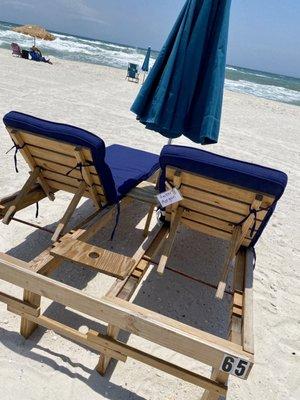 The loungers with the umbrella. It has a small space for drinks in between.