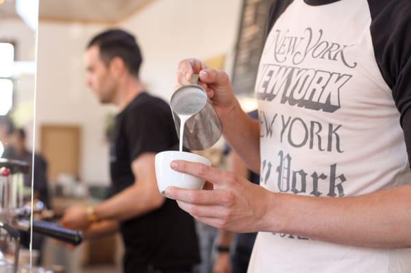 Barista pouring a cappuccino.