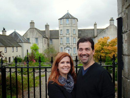 Richard and Kristin Morris, owners of Cruise Planners - Arizona Cruise and Travel outside of a castle while visiting Scotland.