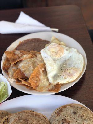 Red chilaquites plate with beans, eggs and potatoes