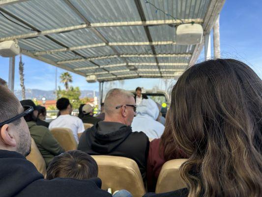 Mid bus seat facing the guide.