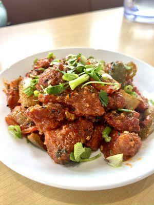 Chili Chicken: Tender chicken pieces stir-fried with bell peppers, onions, and a spicy chili sauce, garnished with green onions.
