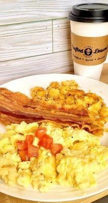 Scrambled eggs , bacon or sausage with hash browns and toast.