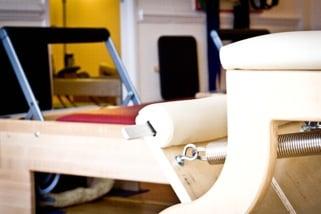 Wunda Chair, Reformer and a sneak peek into the private apparatus room equipped with a reformer, pedi-pole, ladder barrel, and wunda chair.