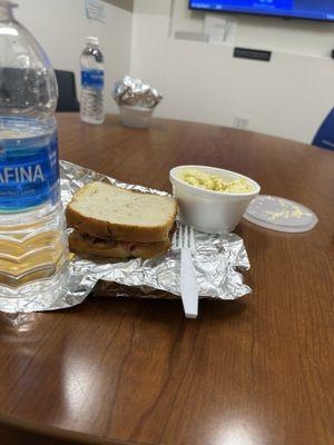 Fried bologna sandwich, water, and potato salad.