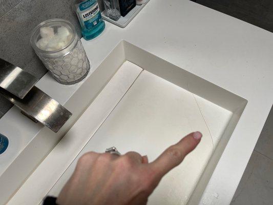 Krion sink, discolored from WATER and cracked by my finger that drips water into the vanity.