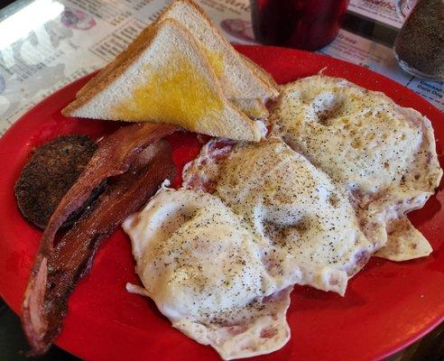 Trucker's special with 3 eggs over medium, sausage, bacon, toast, and a pancake...