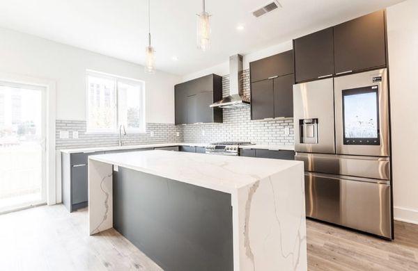 A beautiful kitchen design featuring our countertops, cabinets, flooring, and backsplash all found at Ideal Tile & Kitchen!