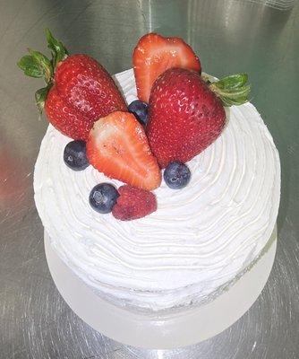Beautiful vanilla cake, covered in smooth buttercream and topped with stawberries,blueberries and raspberries