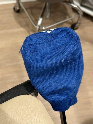 Another angle of the stirrup cover with frayed edges and accumulated lint/debris.