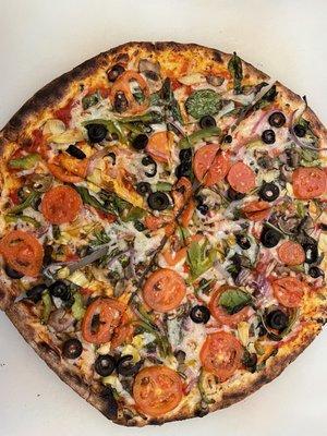 Veggie pizza, with vegan cheese plus artichoke hearts and basil.