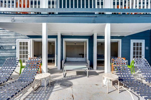 A white patio with a blue house in the background.
