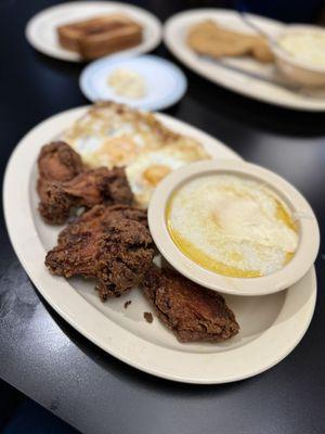Fried chicken platter with eggs fried over-easy, side of buttery grits, wheat toast, coffee