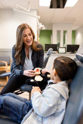 Showing a child how to properly brush their teeth at Kirkland Kids Dentistry