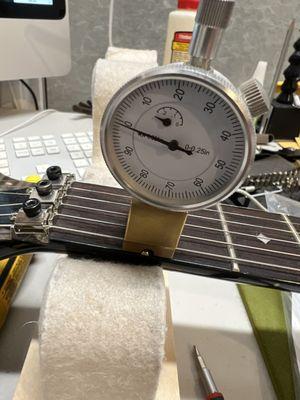 Measuring first fret string heights prior to nut adjustment.