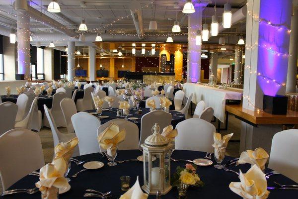 Wide photo of wedding set up in Kirby Student Center featuring table decorations.