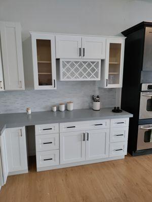 Installation and fabrication White Shaker cabinets ..Light Grey Quartz Countertops Looks good together.