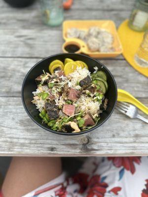 Buddha Bowl with veggie crusted, seared Ahi. Also on the table are dumplings.