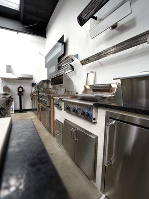 Wall-mounted heaters and built-in grills -- a full outdoor kitchen concept displayed at the Chatsworth showroom.