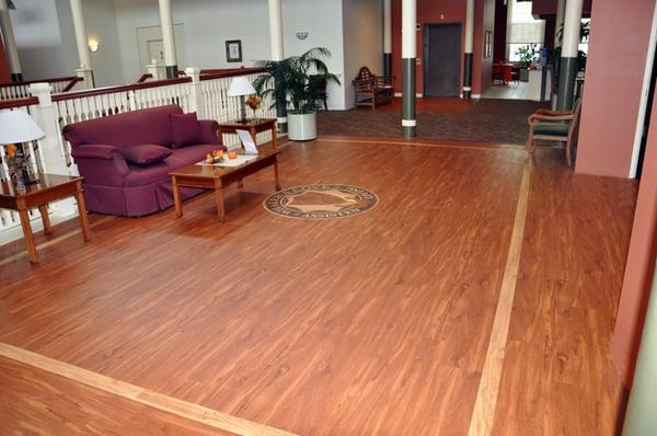 Vinyl plank with custom medallion and borders, alongside carpet tile.