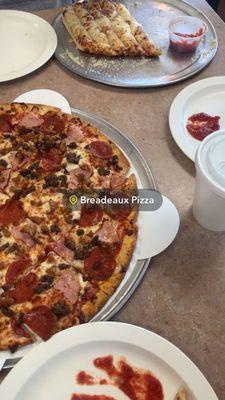 Meat lovers thin crust pizza and cheesy breadsticks.