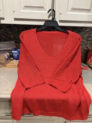 Red sweater 2 sizes too small. Thin material. Poor sewing on sleeves.