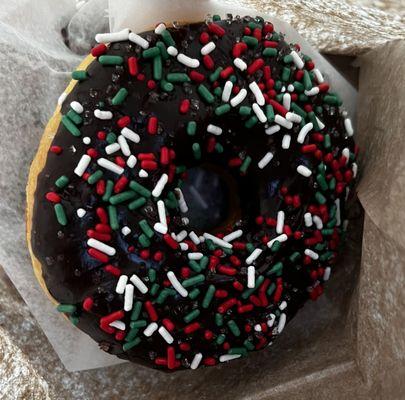 Chocolate-glazed doughnut with Christmas sprinkles