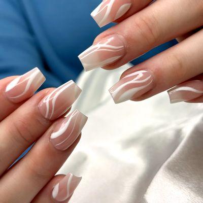Nude nails with elegant white swirl designs.