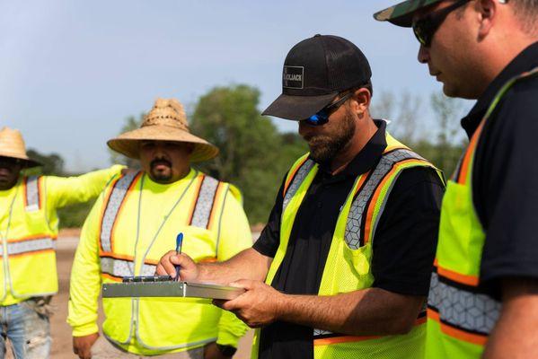 A Blackjack Paving employee writing something down while holding a clipboard
