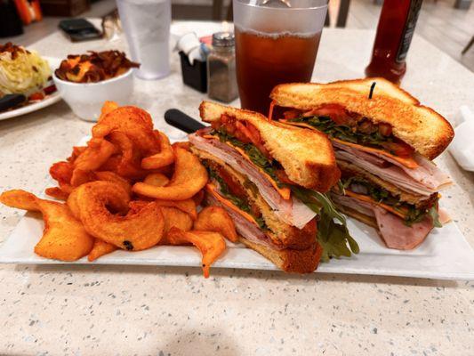 The biggest club sandwich I've ever seen with seasoned fries.