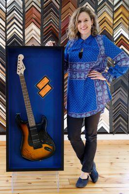 Ellie and the guitar shadow box she framed for a client.