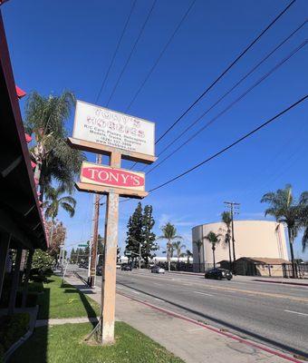 Crusty sign outside ready to fall apart or land on someone. Base of sign all rotted out.