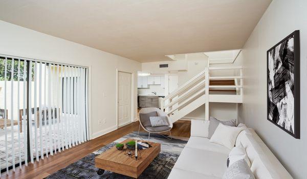 Spacious living room with access to private patio and wood flooring throughout