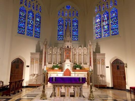 The altar at St. Augustine's RC Church with three large stained glass windows behind it. Beautiful church and nice people.