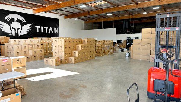 Titan warehouse with stacked product boxes, inventory pallets and forklift, large fulfillment space for cold plunge and chiller shipments