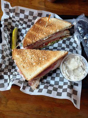 Club sandwich, potato salad, and pickle spear