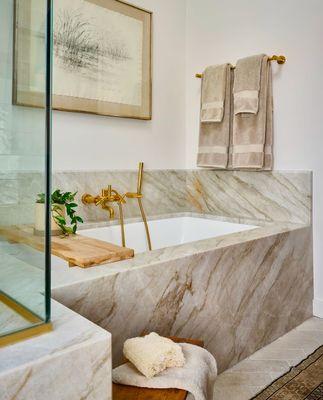 Detailed view of a custom Taj Mahal quartzite bathtub, showing the natural stone veining and craftsmanship in a high-end Atlanta home.
