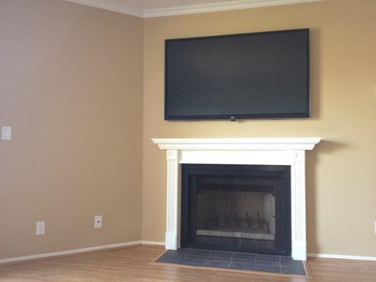60" SmartTV mounted above fireplace with concealed wiring/cables.