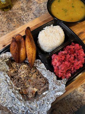 Some kind of shredded beef dish with perfectly cooked plantains and some sort of red cabbage and potato cold salad