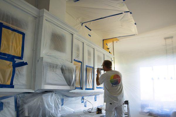 Crew member caulking cabinets.