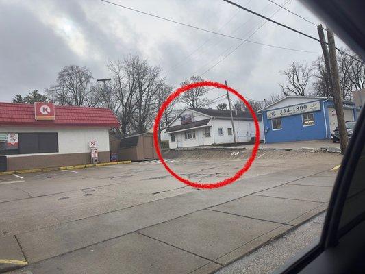 The sign says "Angela's Hair Barbershop." It's in this building but on the other side. The parking lot is exiguous.