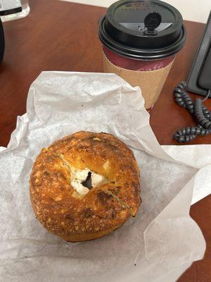 Cheddar jalapeño bagel with cream cheese and a large coffee of the day.