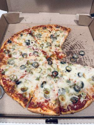 A large "veggie" pizza with green peppers and black olives