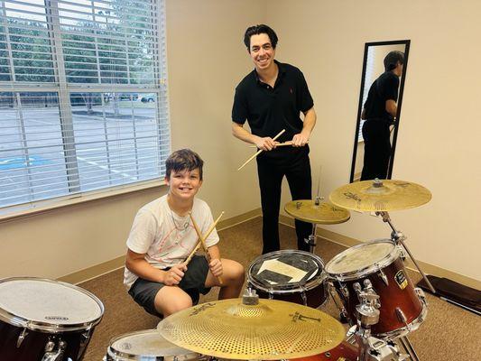 Learning the drums with his instructor, Jaz.