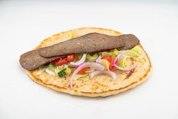 A warm, flavorful gyro loaded with seasoned meat, fresh grilled vegetables, crisp lettuce, and our signature Mediterranean sauce.