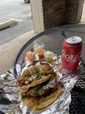 Tacos Al pastor with cilantro and onion, red and green sauce, marinated carrots and peppers, and Coke