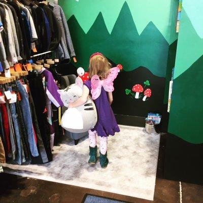 A little fairy off to discover the play area with the shop cat in tow.